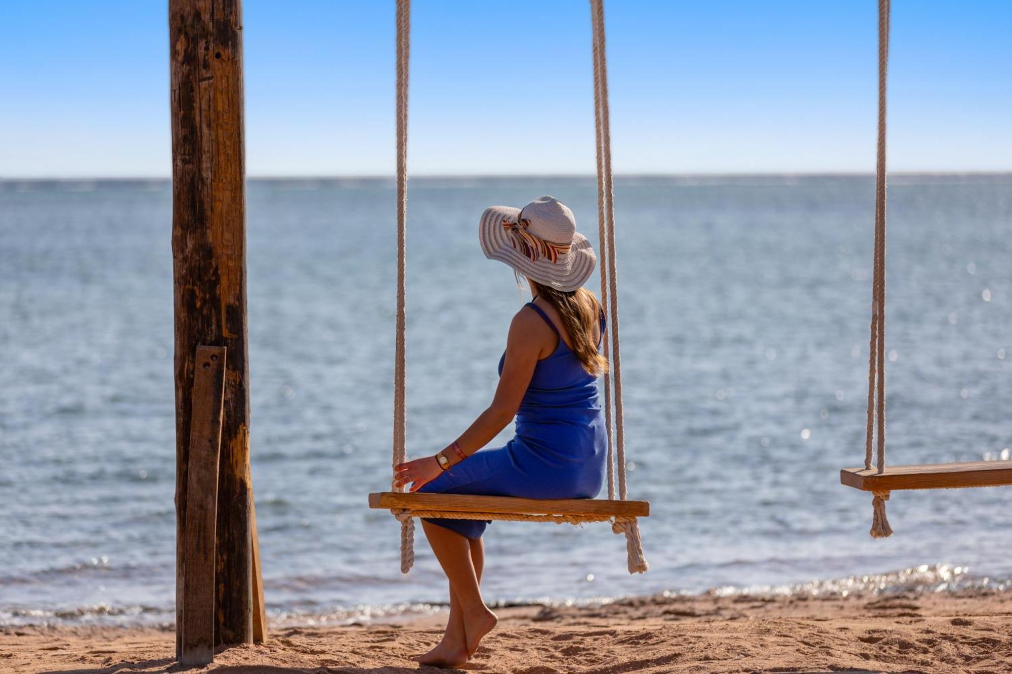 Hotel Pickalbatros Royal Moderna Sharm "Aqua Park" Esterno foto A woman on a swing at the beach